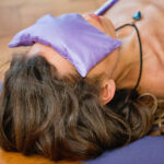Woman in Yoga Savasana position with lavender eye pillow